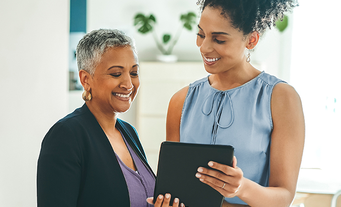 Woman and Man holding book and laptop smiling