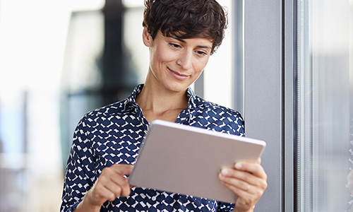 Person standing looking at tablet